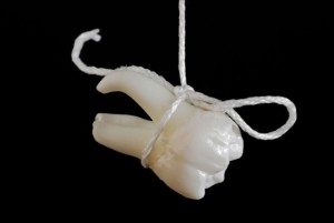 extracted tooth on a string
