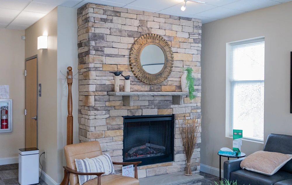 Cozy waiting area with fireplace and seating in creedmoor road dental office