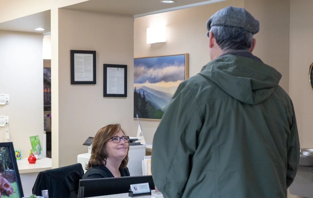Front desk receptionist welcoming patient in creedmoor road dental office