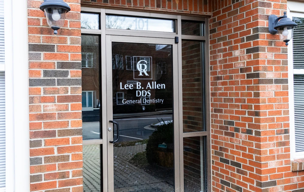 Glass door entrance with signage at creedmoor road dental office