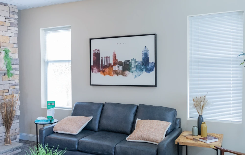 Modern waiting room interior with artwork and natural light in creedmoor road dental office
