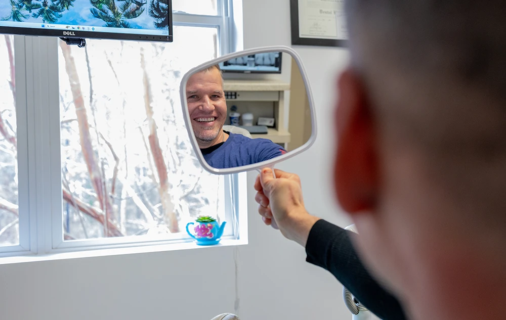 Real Patient Looking At Teeth in Mirror